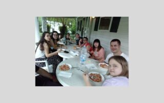 Gruppo giovani con sindrome di Down attorno al tavolo in vacanza